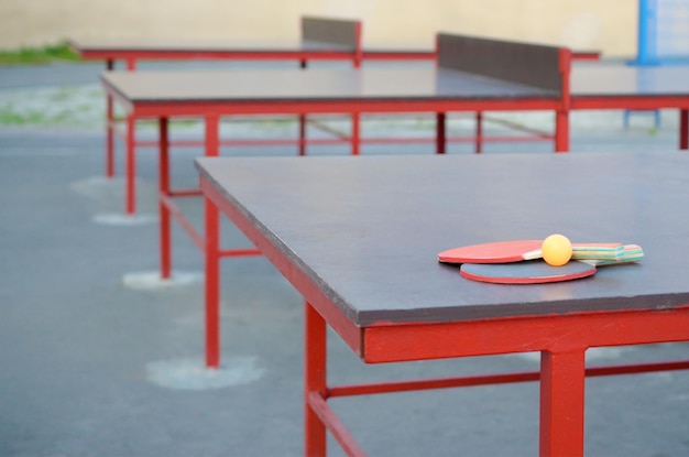 Rackets and ball on Ping pong table in outdoor sport yard Active sports and physical training concept