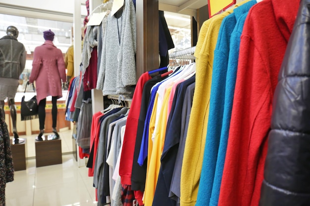 Racks with different clothes in modern shop