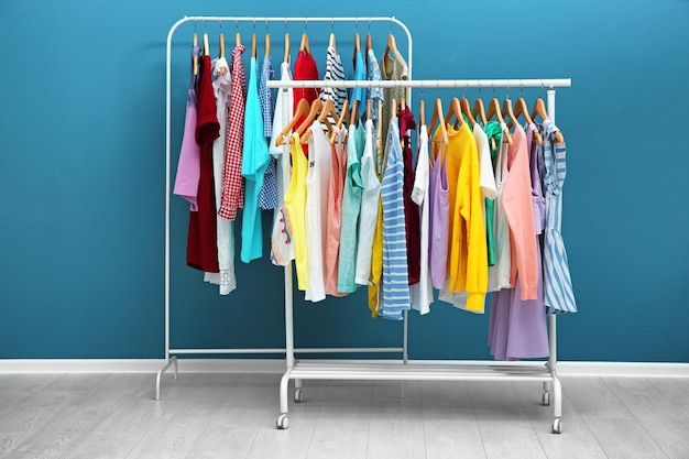 Racks with different clothes near color wall