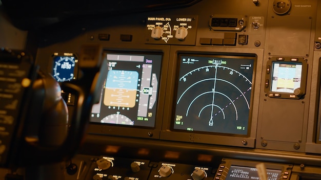 Radar compass and windscreen on dashboard in cockpit used by captain to fly and takeoff with airplane. Power engine lever to throttle, navigation buttons and control panel jet. Close up.