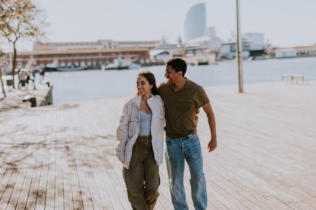 Radiant couple embraces on a sunny Barcelona boardwalk exuding happiness and love