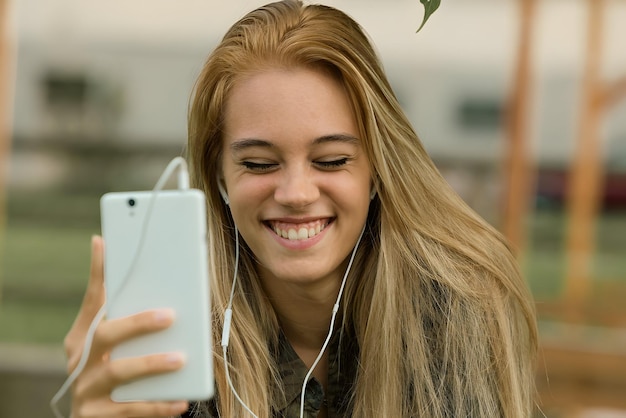 Photo radiant smile on young lady as she enjoys a video call earphones in holding a smartphone