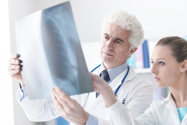 Radiologist checking an xray with his assistant