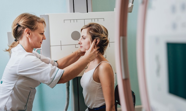 Radiologist and patient in a x-ray room. Classic ceiling-mounted x-ray system.