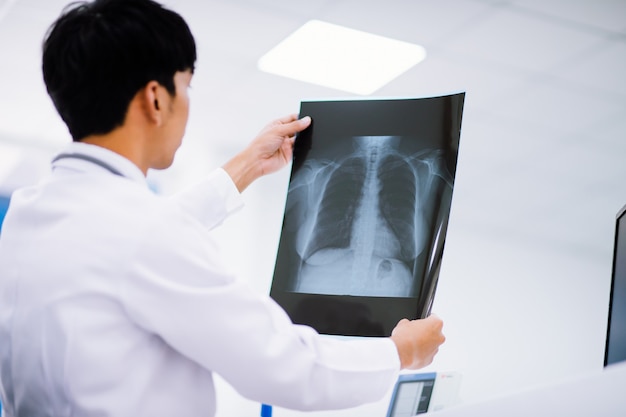 Radiology doctor examining at chest x ray film of patient at health care clinic