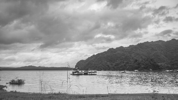 Rafting house on lake .beautiful landscape  with foggy over mountains on background in Kanchanaburi Thailand black and white photography