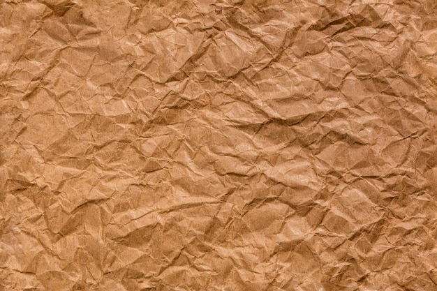 Ragged crumpled brown kraft paper seamless texture and full frame flat background