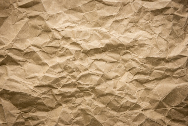 Ragged crumpled brown kraft paper texture background