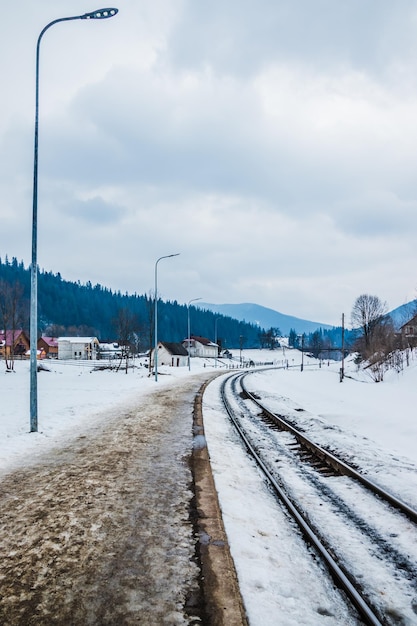 Rails and dirty snow in winter in the mountains A small railway station with one track and snow