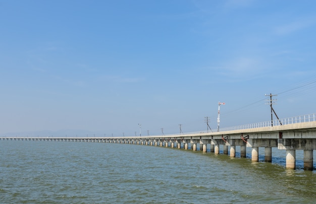 Railway bridge lead across the lake in Thailand