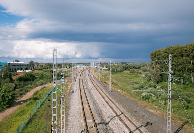 Railway line stretching into the horizon on a background cloudy sky