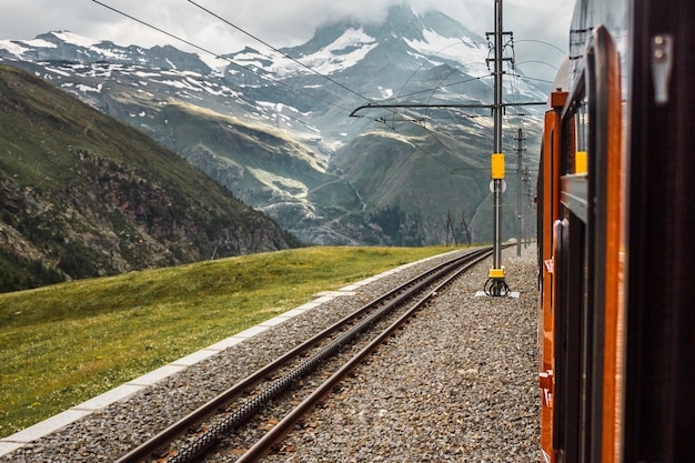 Railway in mountains view from the window of red train Zermatt Swiss Alps travel Switzerland