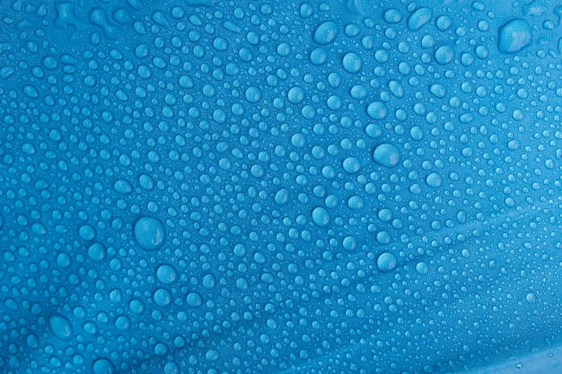 Rain drops on a blue umbrella.