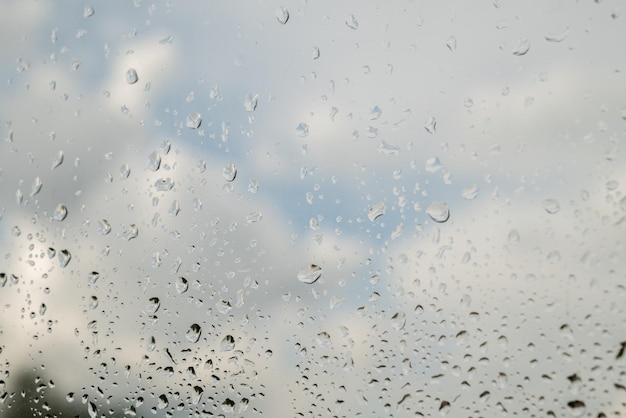 Rain drops on the glass Beautiful blue and white sky Sky background