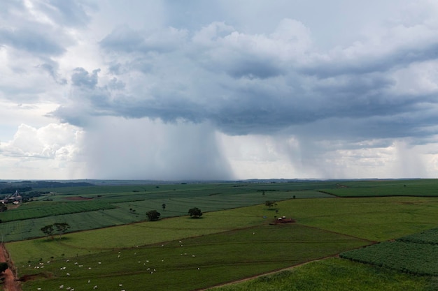 Rain falling from a single cloud on part of rural area drone view