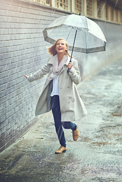 The rain never bothered her anyway Full length shot of an attractive young woman playing in the rain