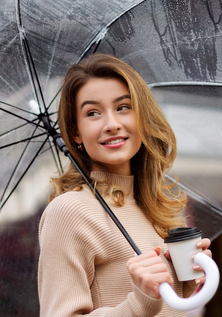 Rain portrait of young beautiful woman with umbrella