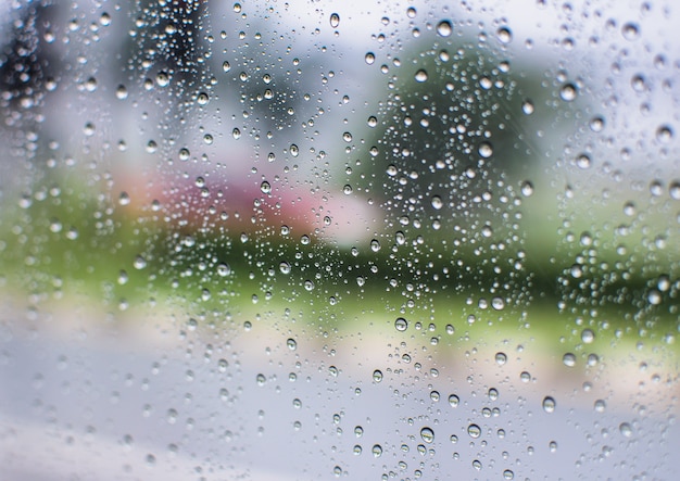 Rain water drops and  text on window with  abstract blur background