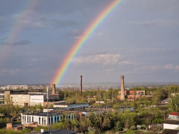 A rainbow over a city with a building in the background