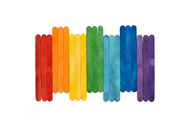 Rainbow color wooden ice cream sticks on white Multicolored abstract