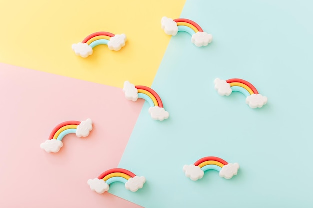 Rainbow erasers with smiling clouds on color background top view