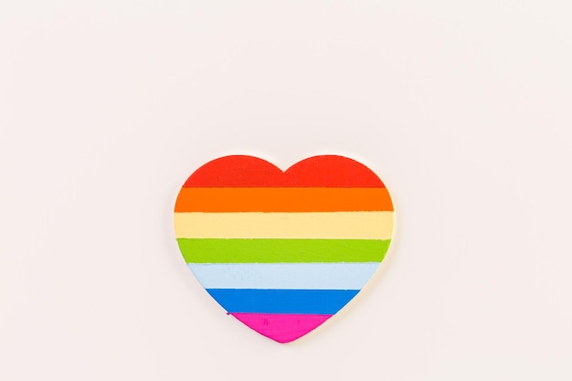 Rainbow Gay Pride heart on a wood background.