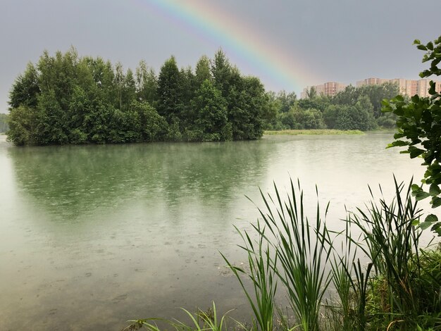 Rainbow over lake durind rain