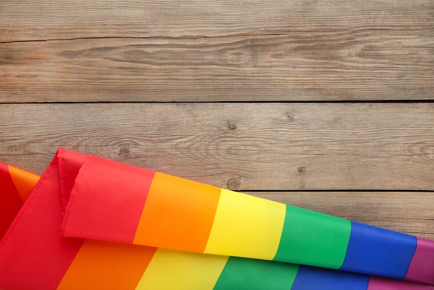 Rainbow LGBT flag on grey wooden background with copy space