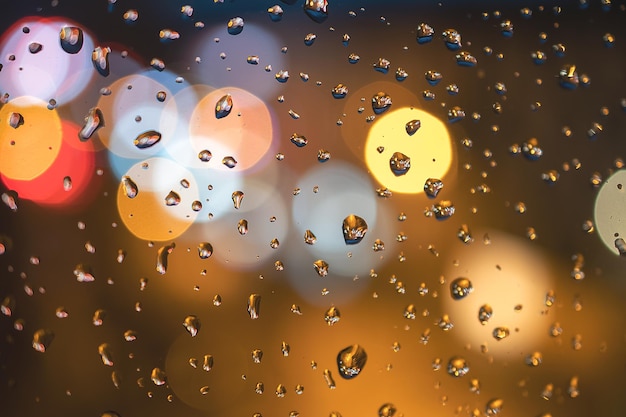 Raindrops on blue glass background Street bokeh out of focus abstract background