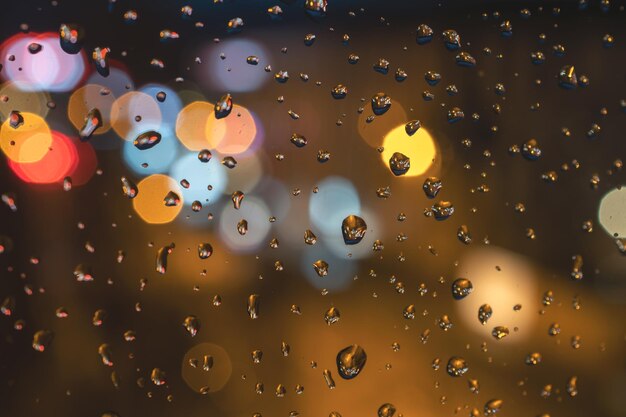 Raindrops on blue glass background Street bokeh out of focus abstract background