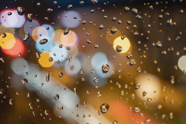 Raindrops on blue glass background Street bokeh out of focus abstract background