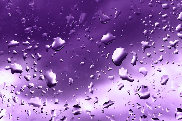 Raindrops on glass for purple backdrop rainy fall autumn weather Abstract backgrounds with rain drops on window