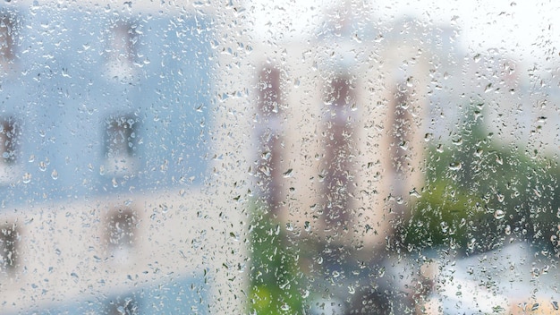 Raindrops on window and blurred appartment houses