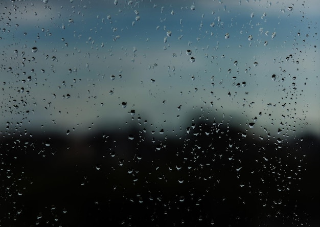 Raindrops on window glass. Rainy city background