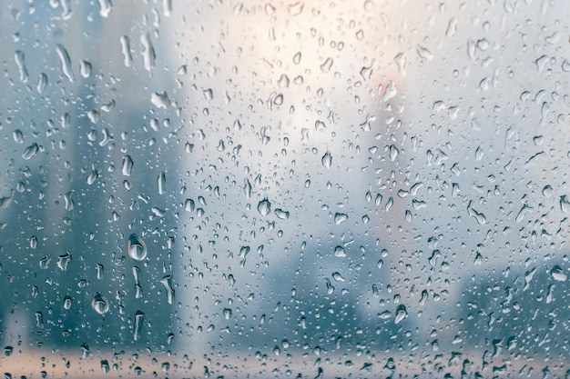 Raindrops over the window with buildings of the city in the background