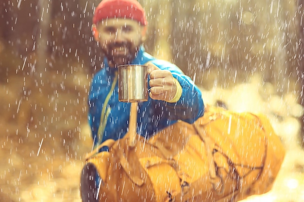 rainy autumn forest, landscape, a man on a hike in the October wet forest, bad cold weather