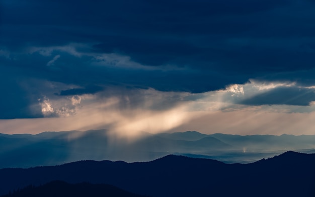 The rainy clouds above the beautiful mountain landscape