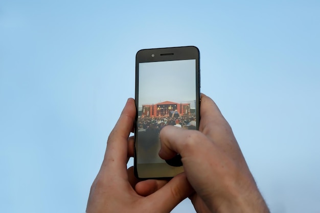 Raised hand with mobile phone Fan taking photos at a outdoor concert