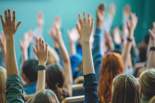 Raised hands and arms of large group of people in class room audience voting in professional education