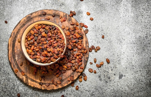 Raisins in a bowl on rustic background 