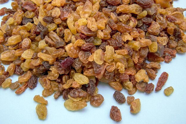 Raisins of different varieties on a light blue background culinary background