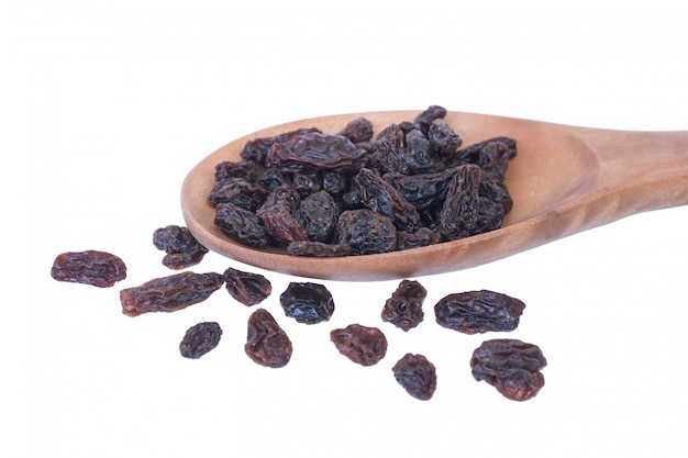 Raisins (Sultanas) in spoon wood isolated on white 