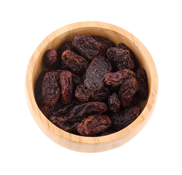 Raisins in wooden bowl isolated