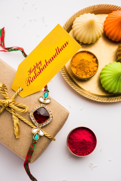 Raksha Bandhan / Rakshabandhan Rakhi with Haldi Kumkum rice, sweet Mithai, Gift Box, selective focus