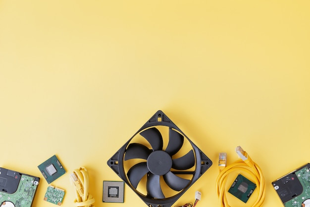 RAM SO-DIMM, CPU, fan, USB, Wi-Fi module, hard drives, patch-cord on the yellow background flat lay