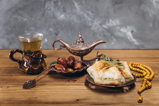 Ramadan concept cup of tea plate of sweet dates and baklava copy space