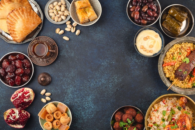 Ramadan kareem Iftar party table with assorted festive traditional Arab dishes, sweets, dates. Eid al-Fitr mubarak evening grand meal, top view. Islamic holidays food, Ramadan feast, space for text