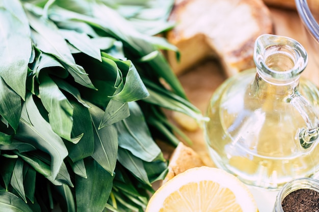 Ramson on a cutting board with oil bottle and lemon