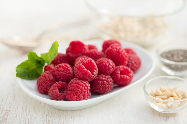 Raspberries on white dish on wooden