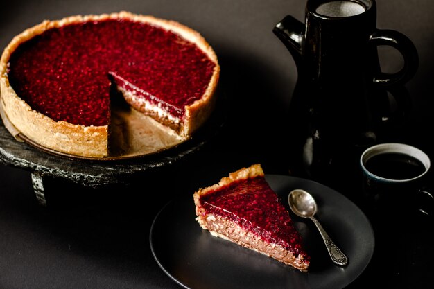 Raspberry coconut chocolate homemade tart pastries with berry on an elegant dark surface